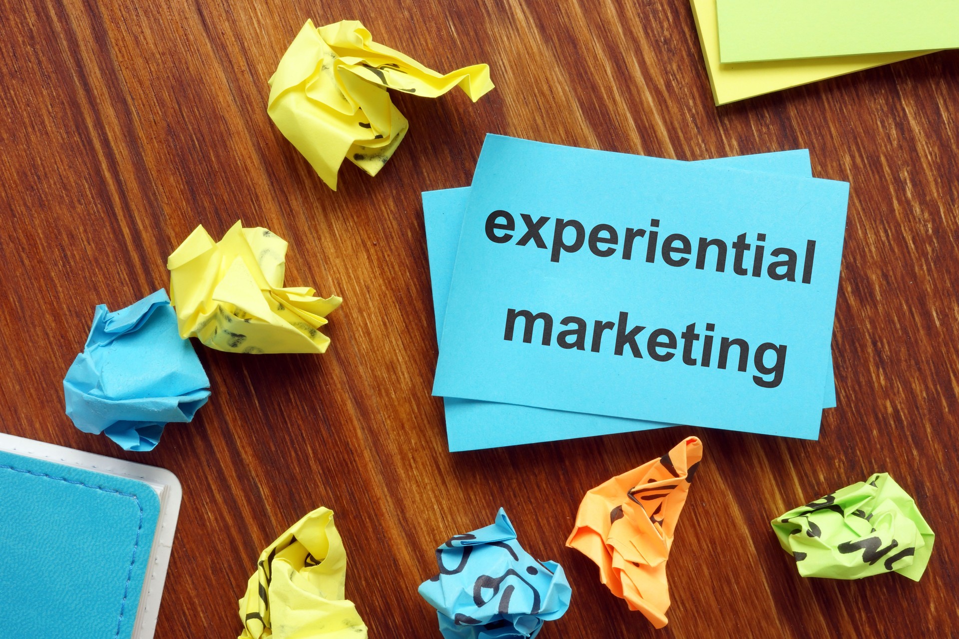 Writing note showing experiential marketing. The text is written on a small colored paper.